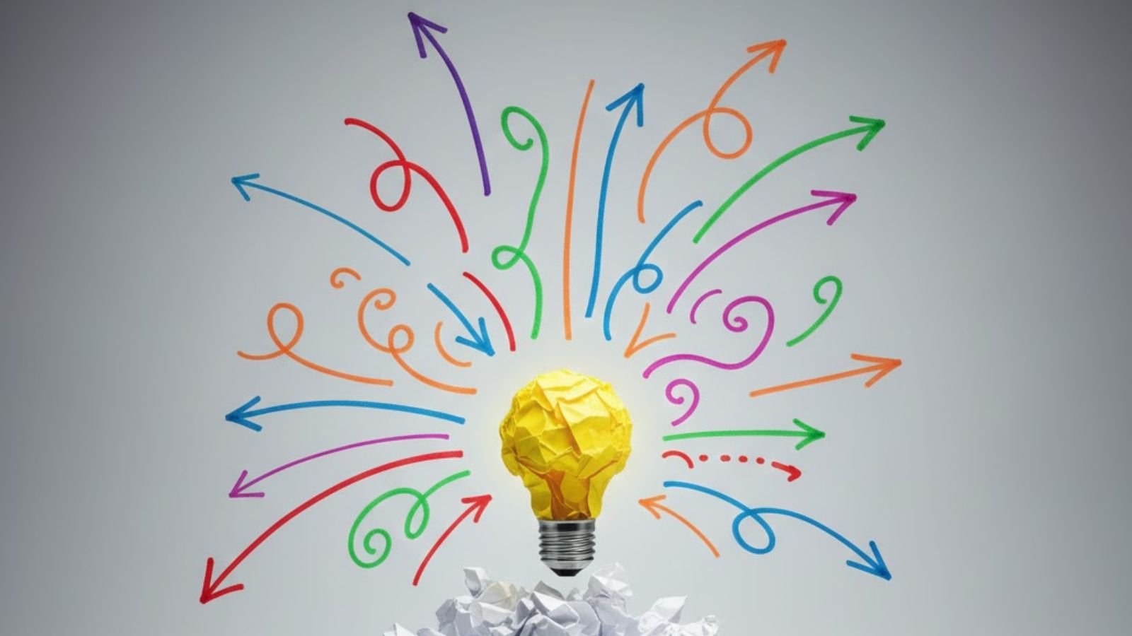 Crumpled yellow paper as lightbulb with colorful hand-drawn arrows